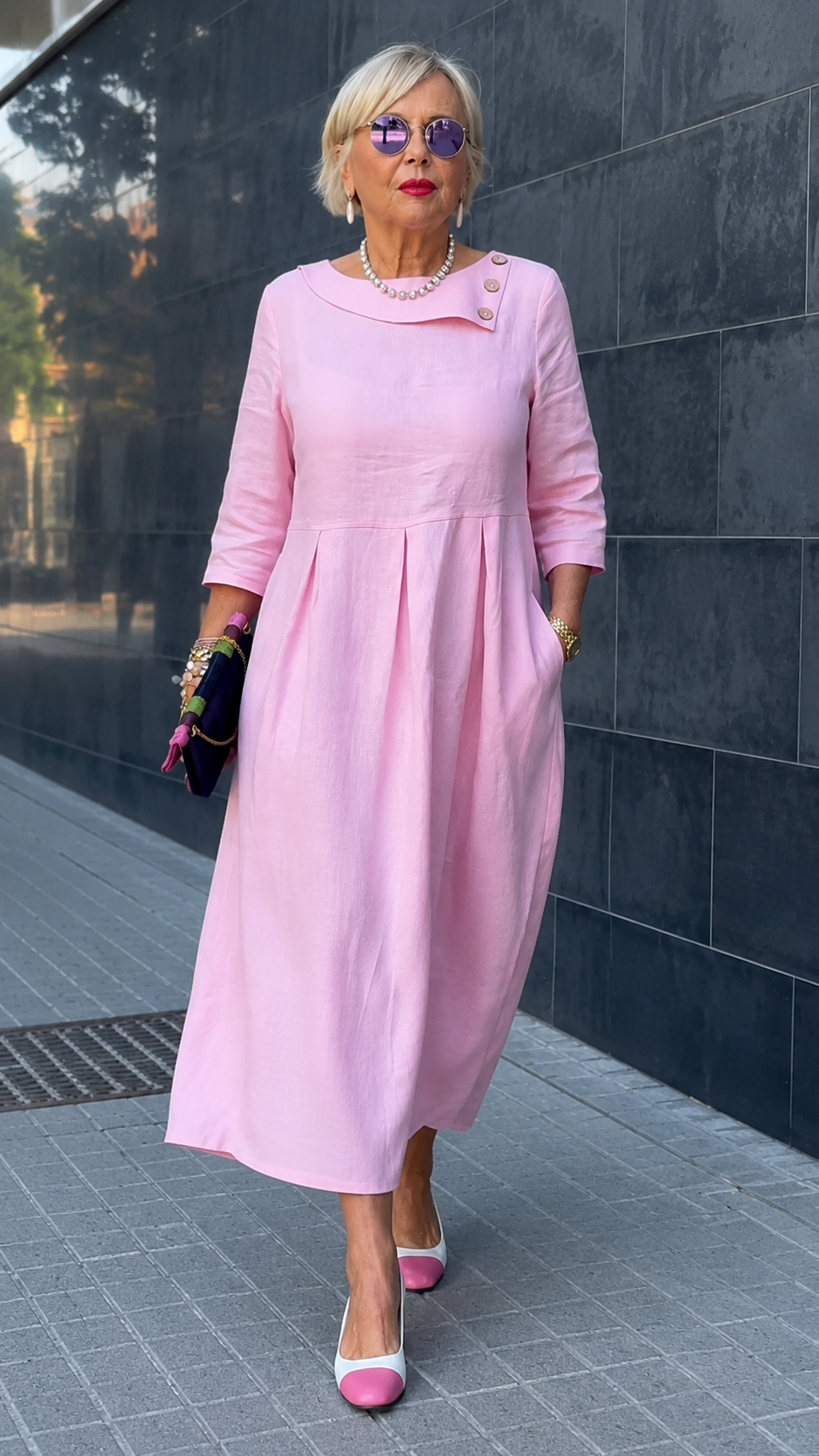 Front view of blush pink pleated midi maxi dress with 3/4 sleeves and decorative shoulder buttons