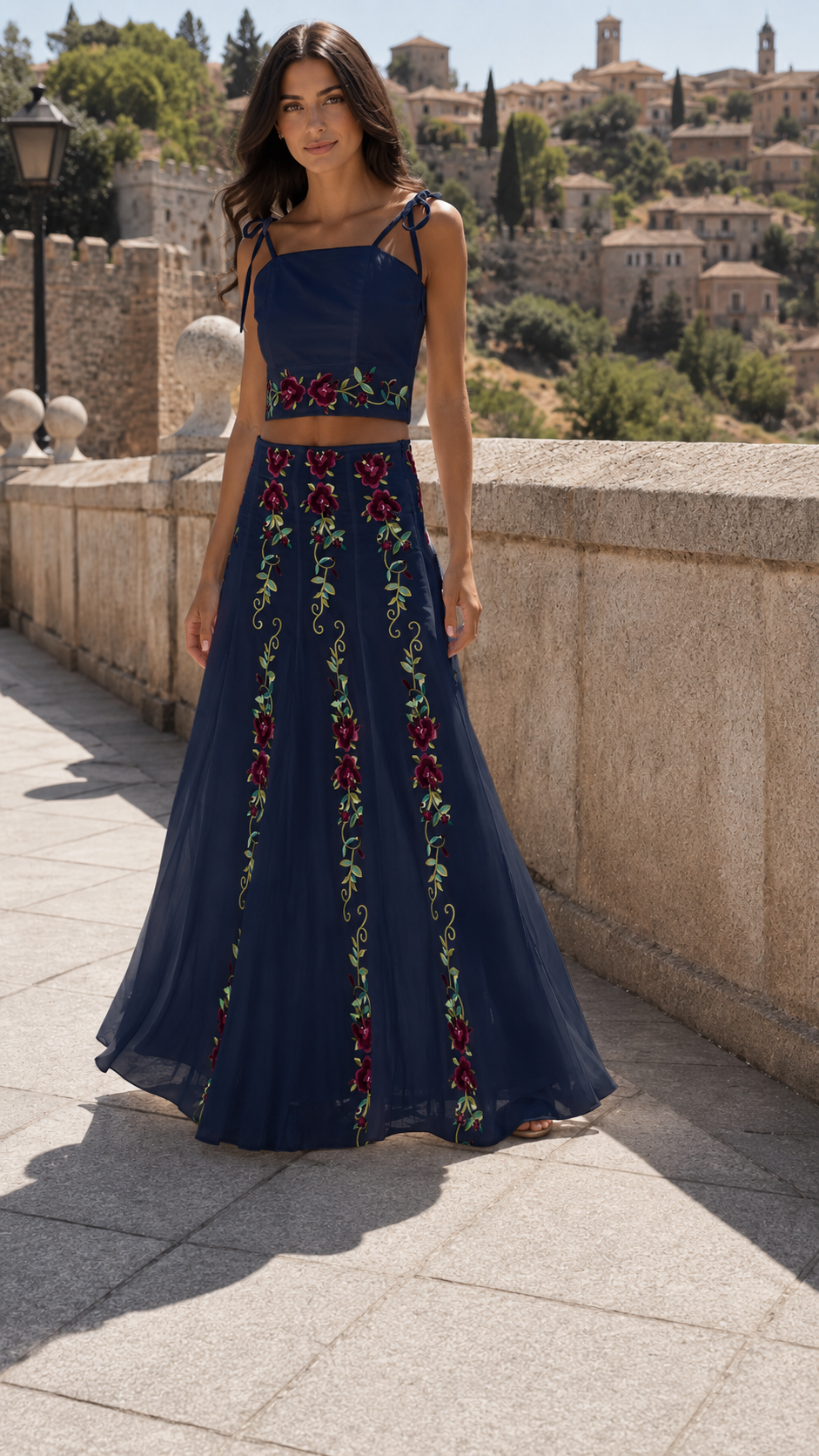 Model wearing a navy floral embroidered tie-strap crop top and flowing maxi skirt set