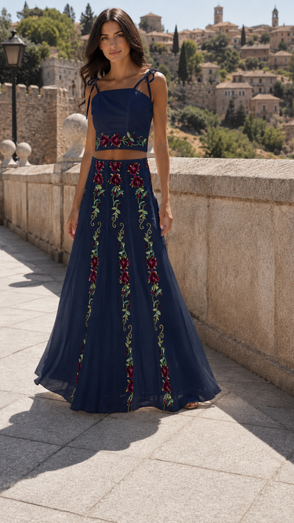 Model wearing a navy floral embroidered tie-strap crop top and flowing maxi skirt set