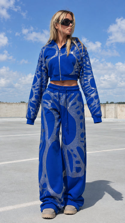 Model wearing royal blue rhinestone cropped hoodie and wide leg sweatpants tracksuit set front view