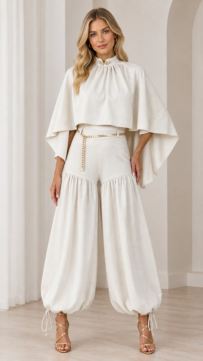 Front full view of woman wearing ivory high-neck cape top and balloon pants set