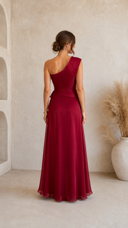 Burgundy one-shoulder maxi dress back view with flowing floor-length skirt