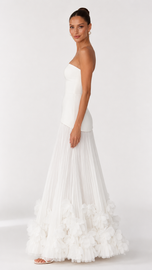 Side view of ivory strapless maxi dress with fitted bodice and full pleated skirt