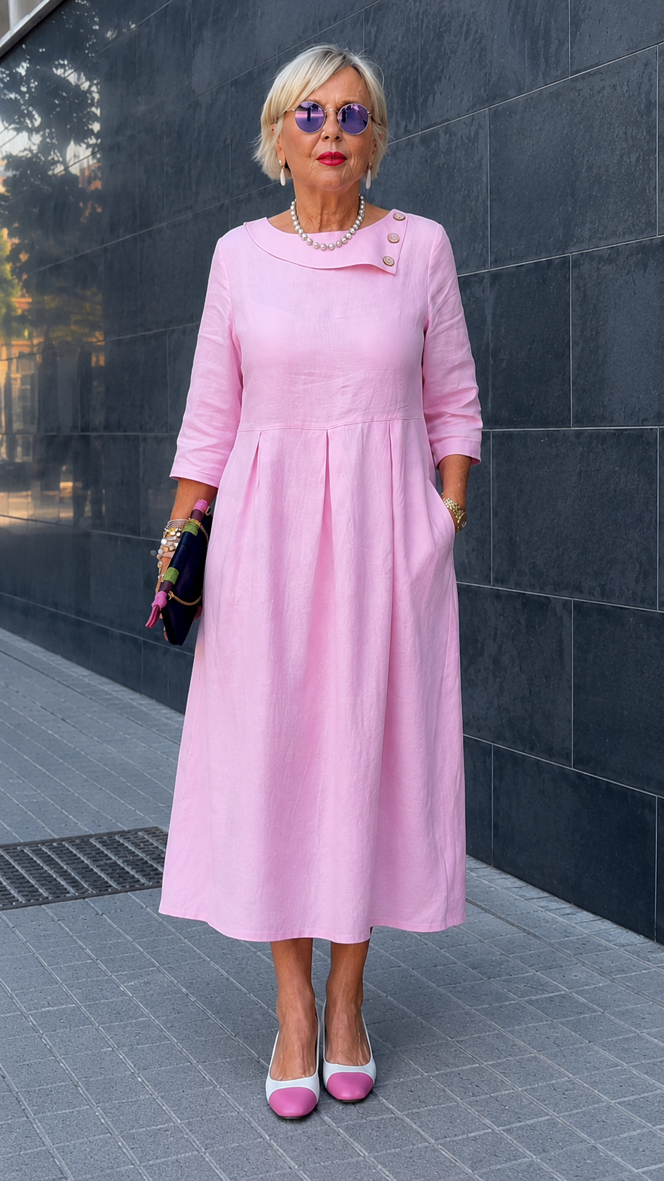 Full-length front view of soft pink dress with pleated skirt and asymmetric neckline detail