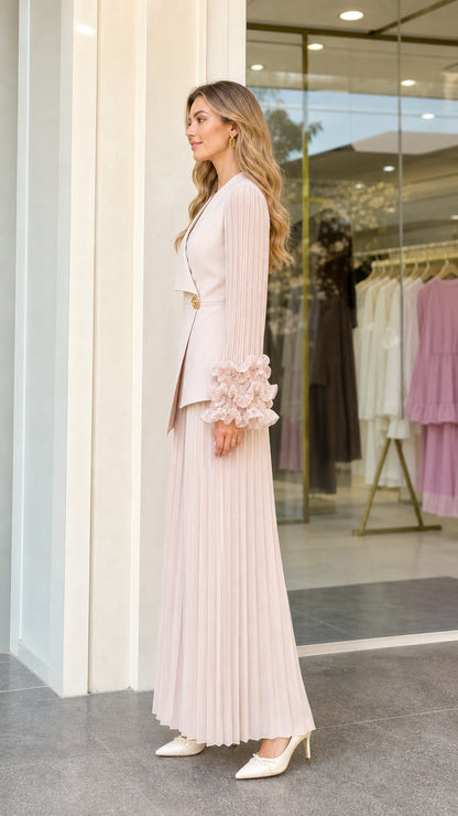 Side view of woman wearing blush pink pleated pant and blazer two-piece set