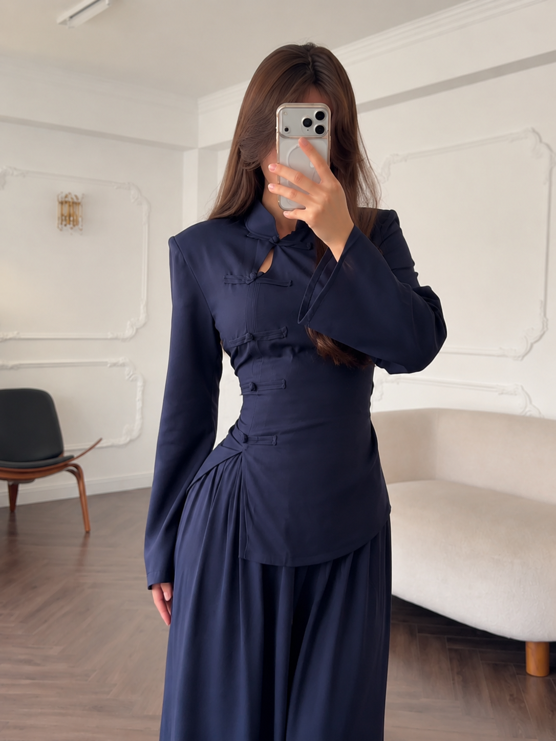 Close front view of the navy top showing keyhole neckline and decorative knot closures