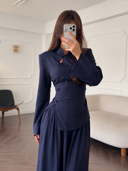 Close front view of the navy top showing keyhole neckline and decorative knot closures