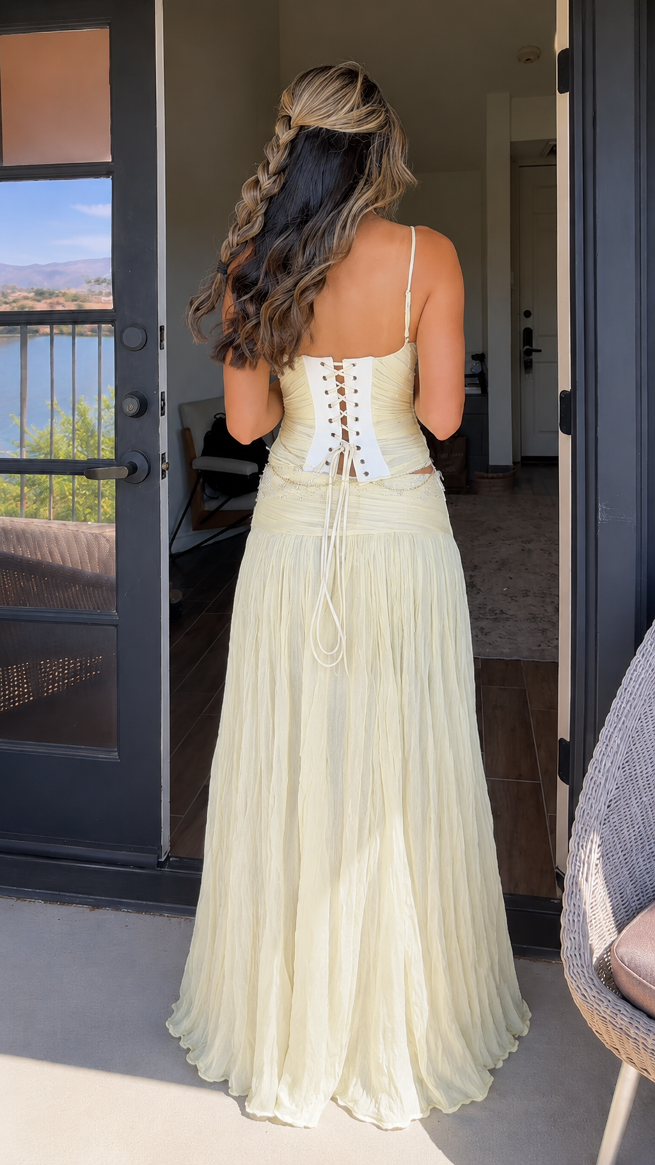 Back view of butter yellow two-piece set with lace-up corset back and flowing maxi skirt