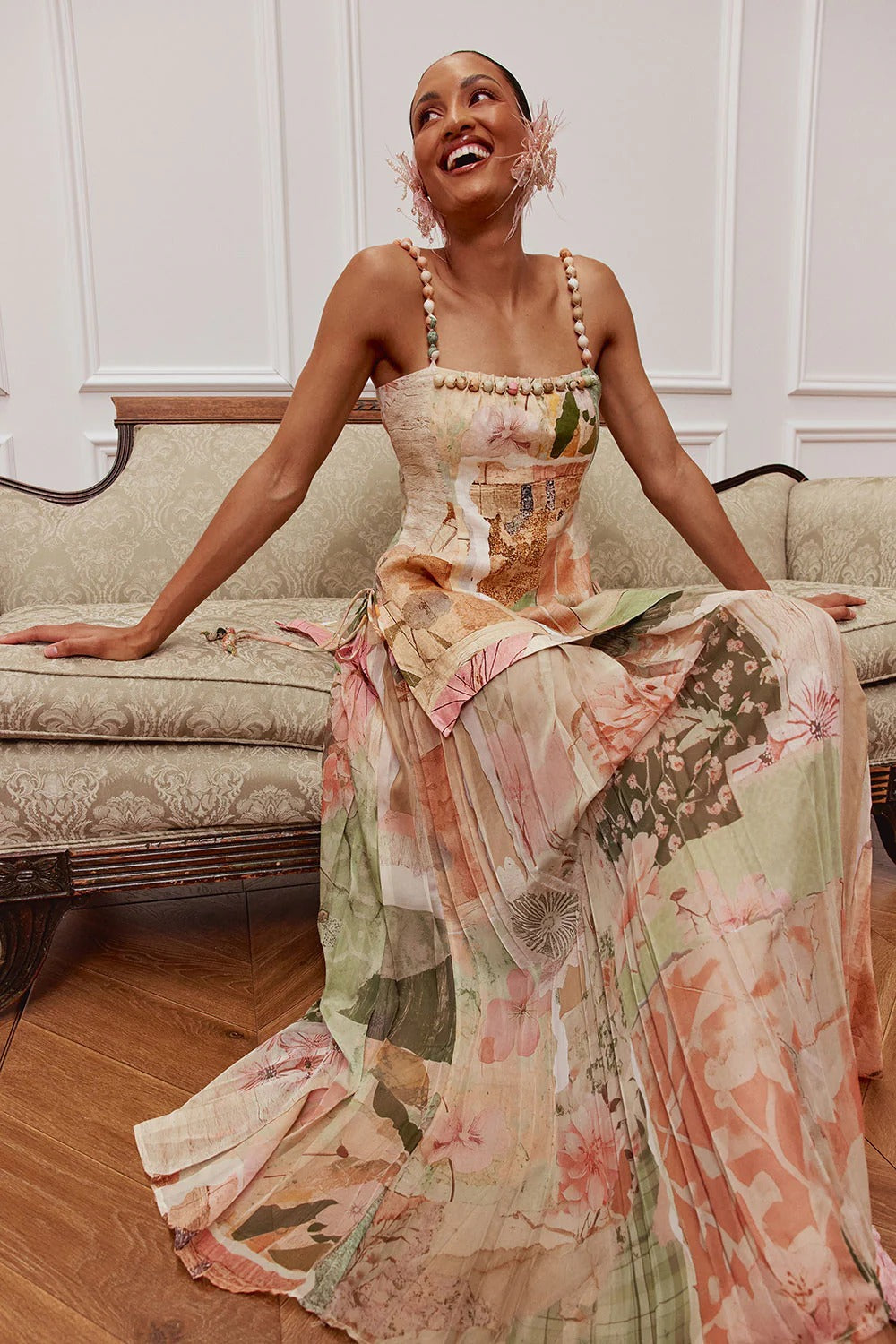 Seated view of the pastel floral maxi dress showing the soft drape and full-length skirt