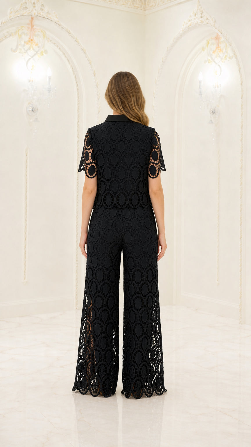 Back full-length view of woman wearing black geometric lace short sleeve shirt and wide-leg trousers