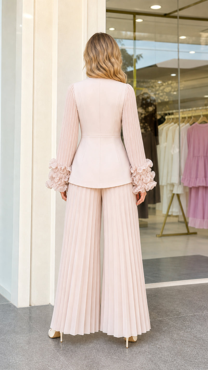 Back view of woman wearing blush pink pleated suit set