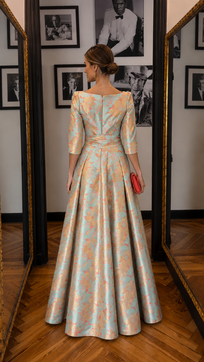 Back view of aqua and peach floral jacquard evening gown with fitted waist and sweeping skirt