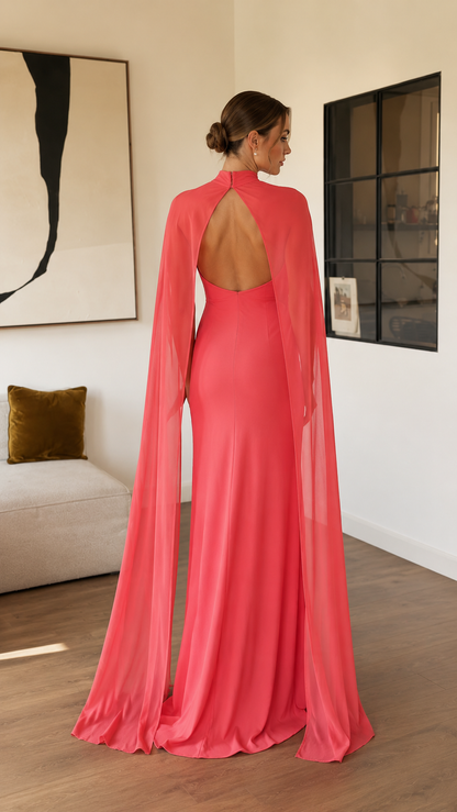 Back view of coral pink open back maxi dress with long cape panels
