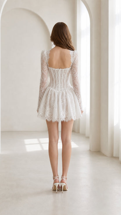 Back view of model in white long sleeve lace mini dress with open back