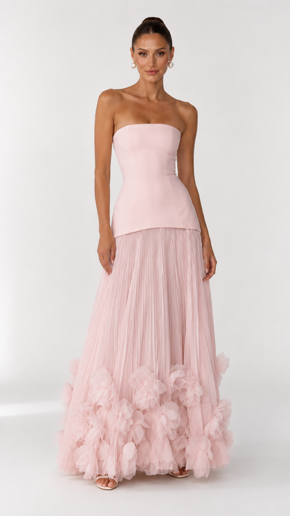 Front view of blush pink strapless maxi dress with pleated skirt and floral hem