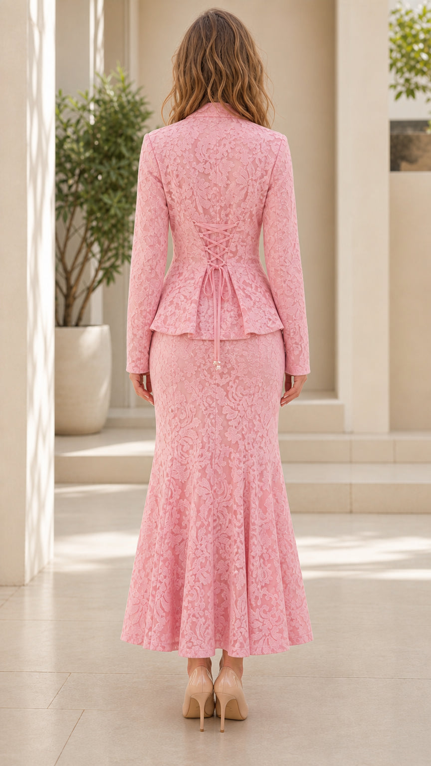 Back view of pink lace jacket showing adjustable lace-up detail and trumpet skirt hem