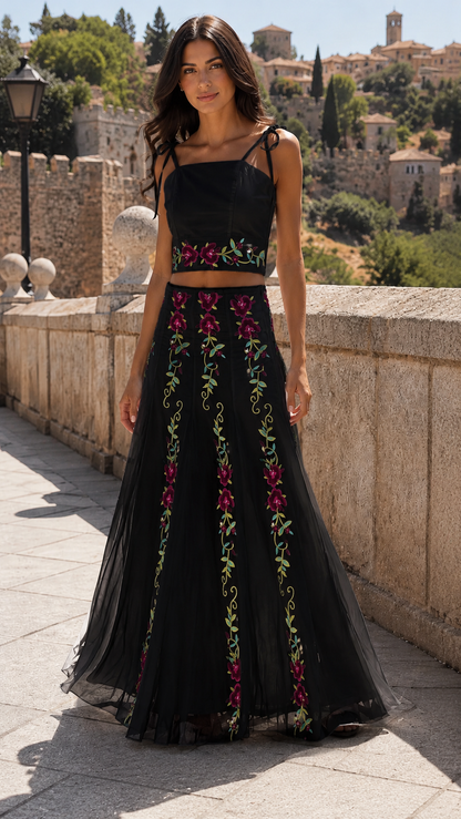 Model wearing a black floral embroidered crop top and maxi skirt two-piece set