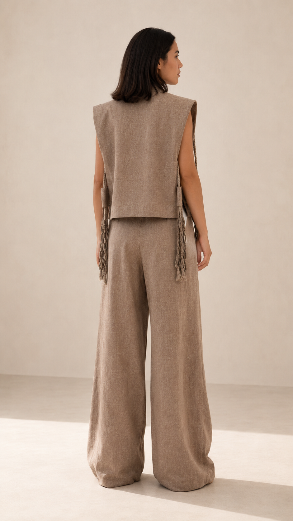 Back view of taupe two-piece sleeveless vest and wide leg pants set