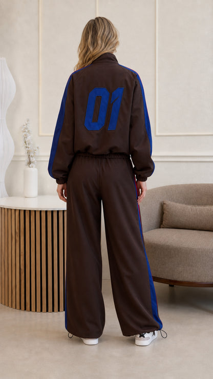 Back view of woman wearing brown tracksuit featuring blue number 01 print