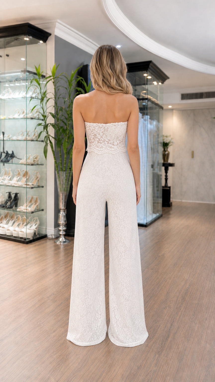 Back view of woman wearing white strapless wide-leg lace jumpsuit