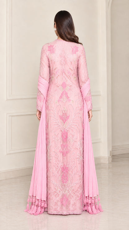 Back view of model wearing light pink embroidered maxi gown with long scarf