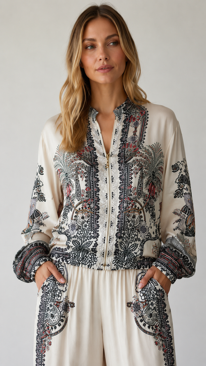 Close-up of ivory zip-front printed top with stand neckline and gathered cuffs