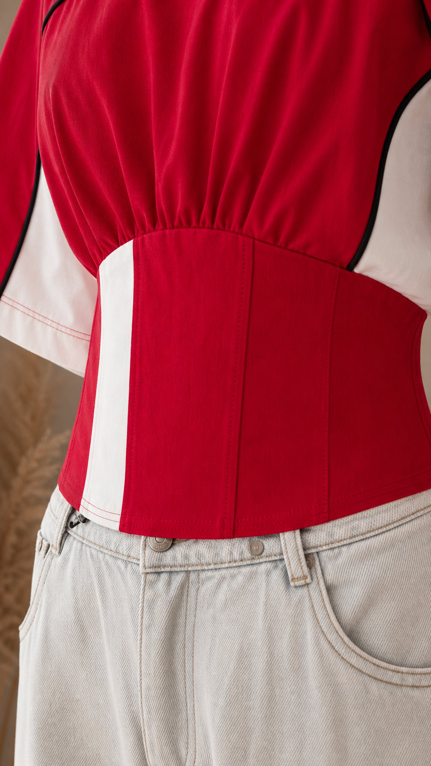 Close-up of the red top showing gathered waist construction and contrast paneling