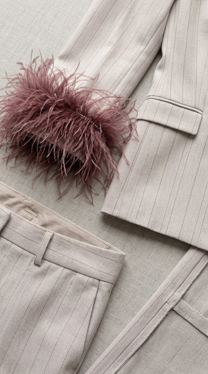 Close-up detail of textured light grey pinstripe fabric and mauve feather cuff trim