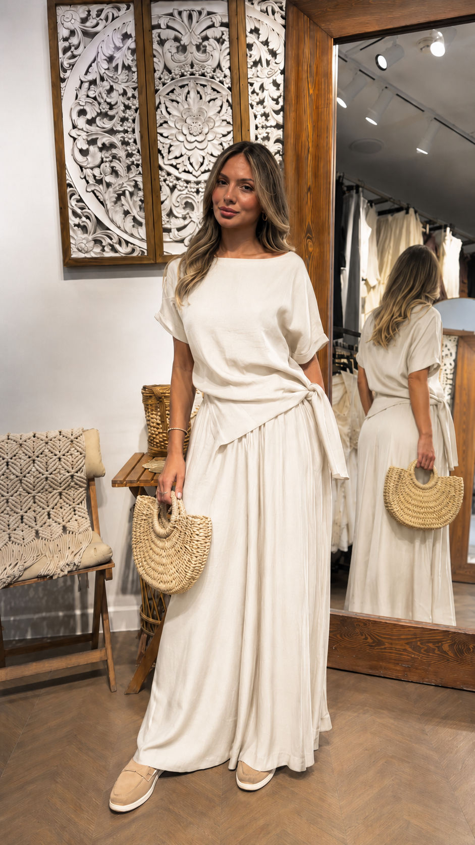 Woman wearing an ivory draped waist maxi dress with a soft flowing silhouette