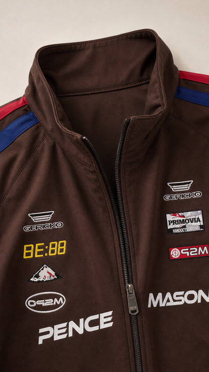 Close-up detail of collar, front zipper, and racing graphic prints on brown track jacket
