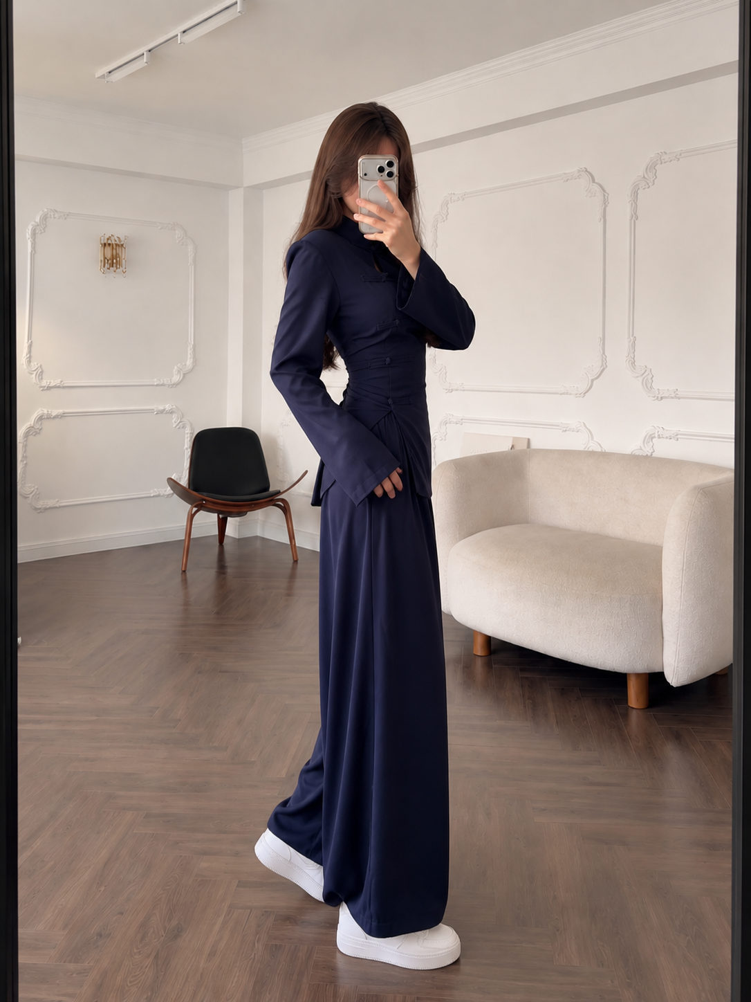 Side view of the navy two-piece outfit with shaped waist and long sleeves