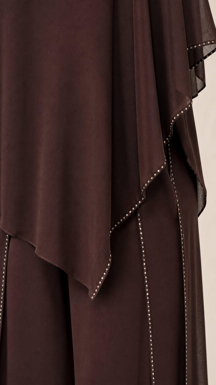 Close-up detail of the asymmetric hemline and sparkling rhinestone edge trim