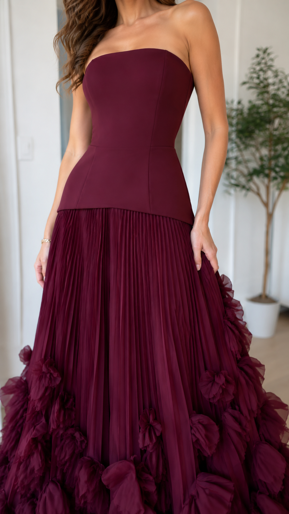 Close-up of burgundy strapless bodice and pleated skirt detail