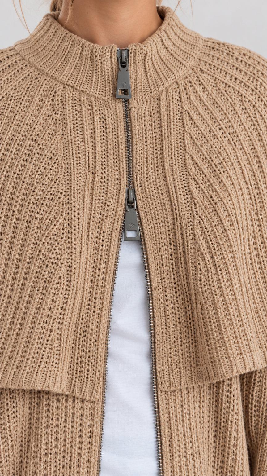Close-up detail of mock neck ribbed knit and metallic zipper front closure
