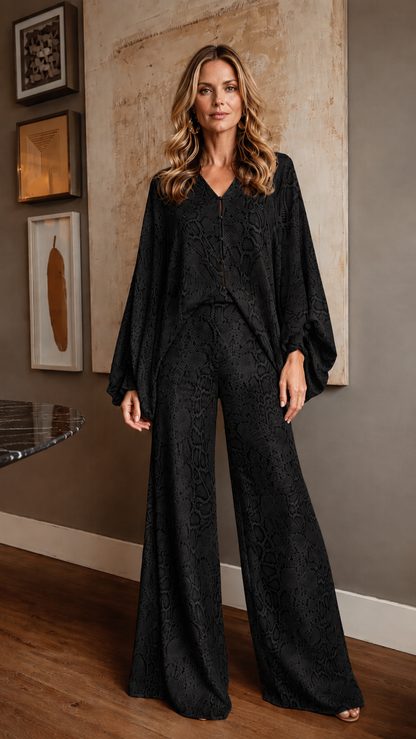 Front view of black snake print wide leg jumpsuit with batwing sleeves