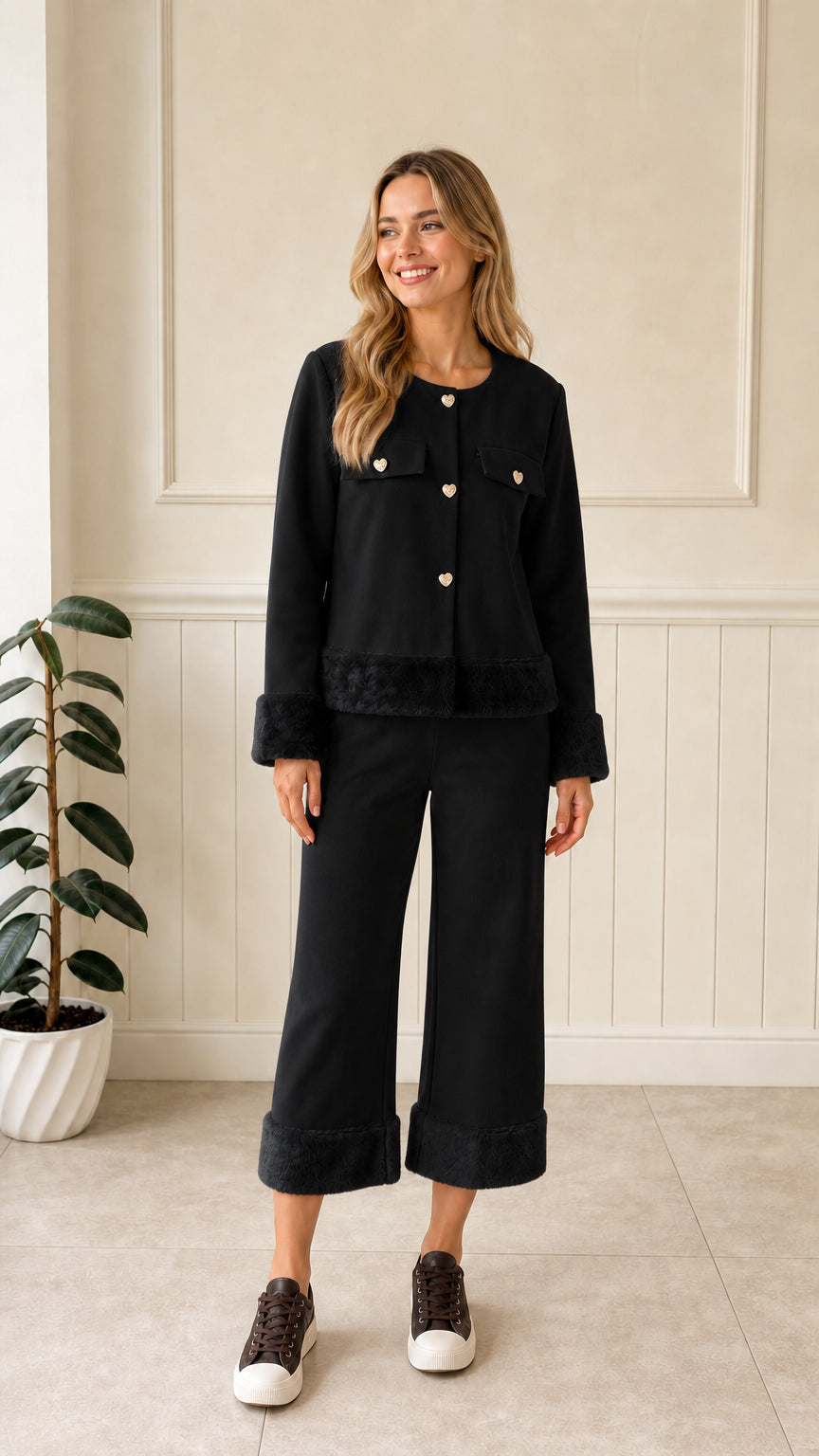 Front view of woman wearing black faux fur trim jacket and matching cropped pant set