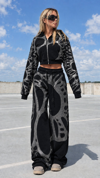 Model wearing black rhinestone cropped zip hoodie and wide leg sweatpants set