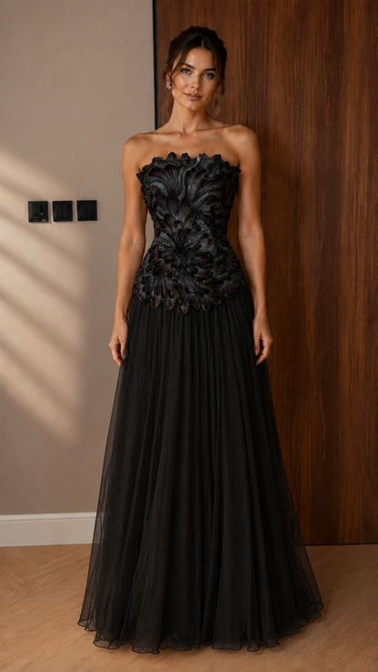 Front view of black strapless appliqué evening gown with pleated floor-length skirt