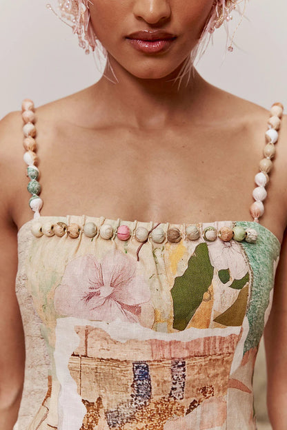 Close-up of the straight neckline and beaded shoulder straps on the floral dress