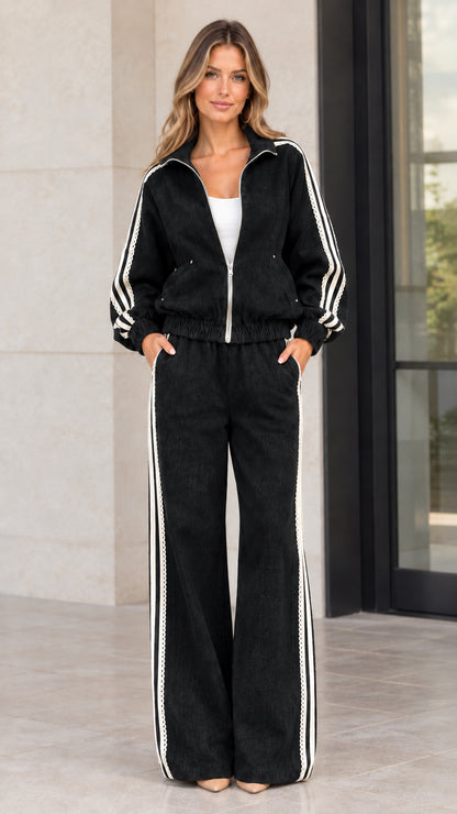 Front view of woman wearing black corduroy zip-up track jacket and wide-leg pants set