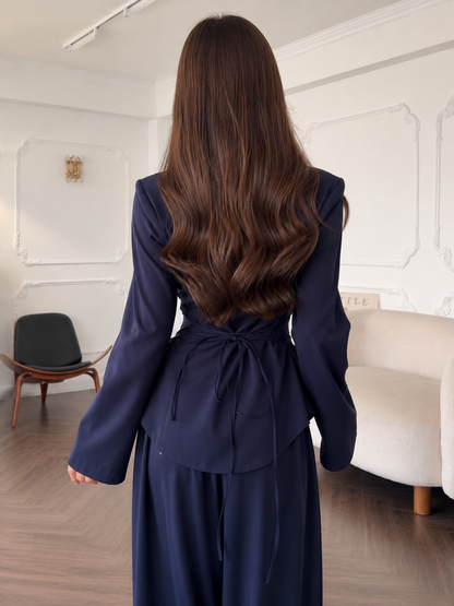 Back view of the navy fitted top with self-tie waist detail and matching pants