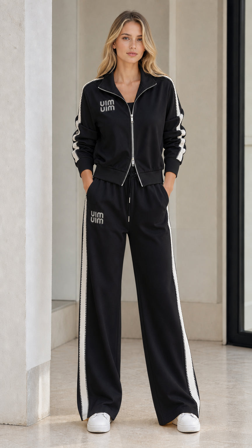 Model wearing Black zip-up track jacket and wide-leg matching sweatpants set