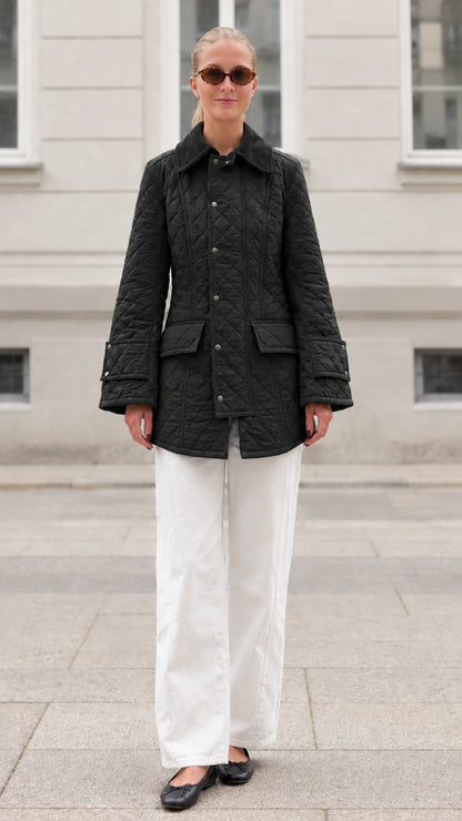 Front full-length view of woman wearing black diamond quilted barn jacket