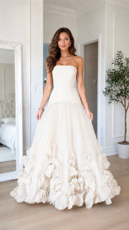 Front view of ivory strapless pleated formal gown with full floral-style hem