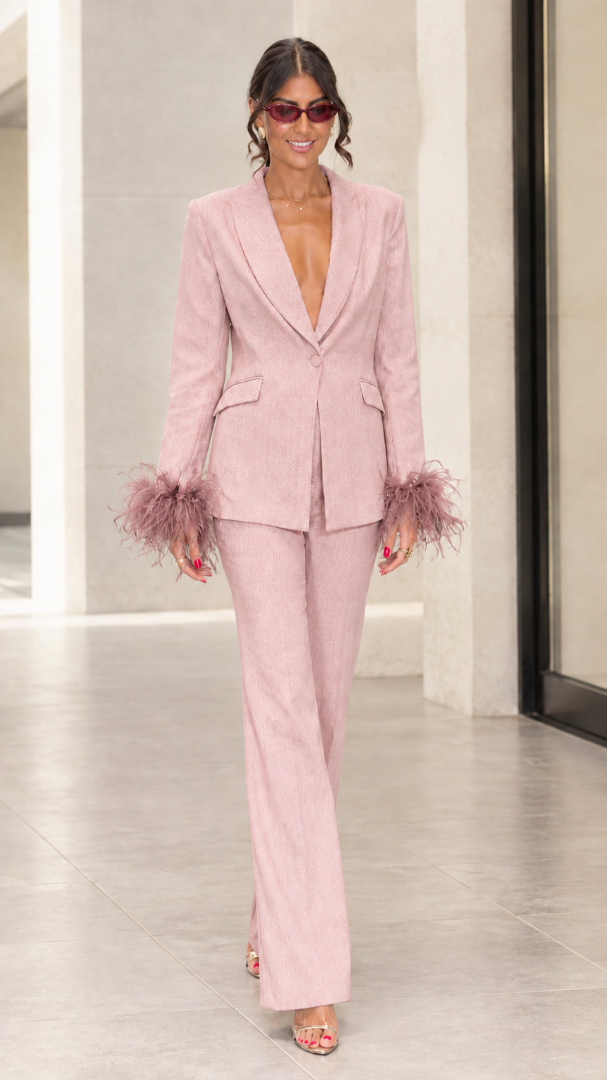 Front view of woman wearing blush pink tailored suit set with tonal feather cuffs