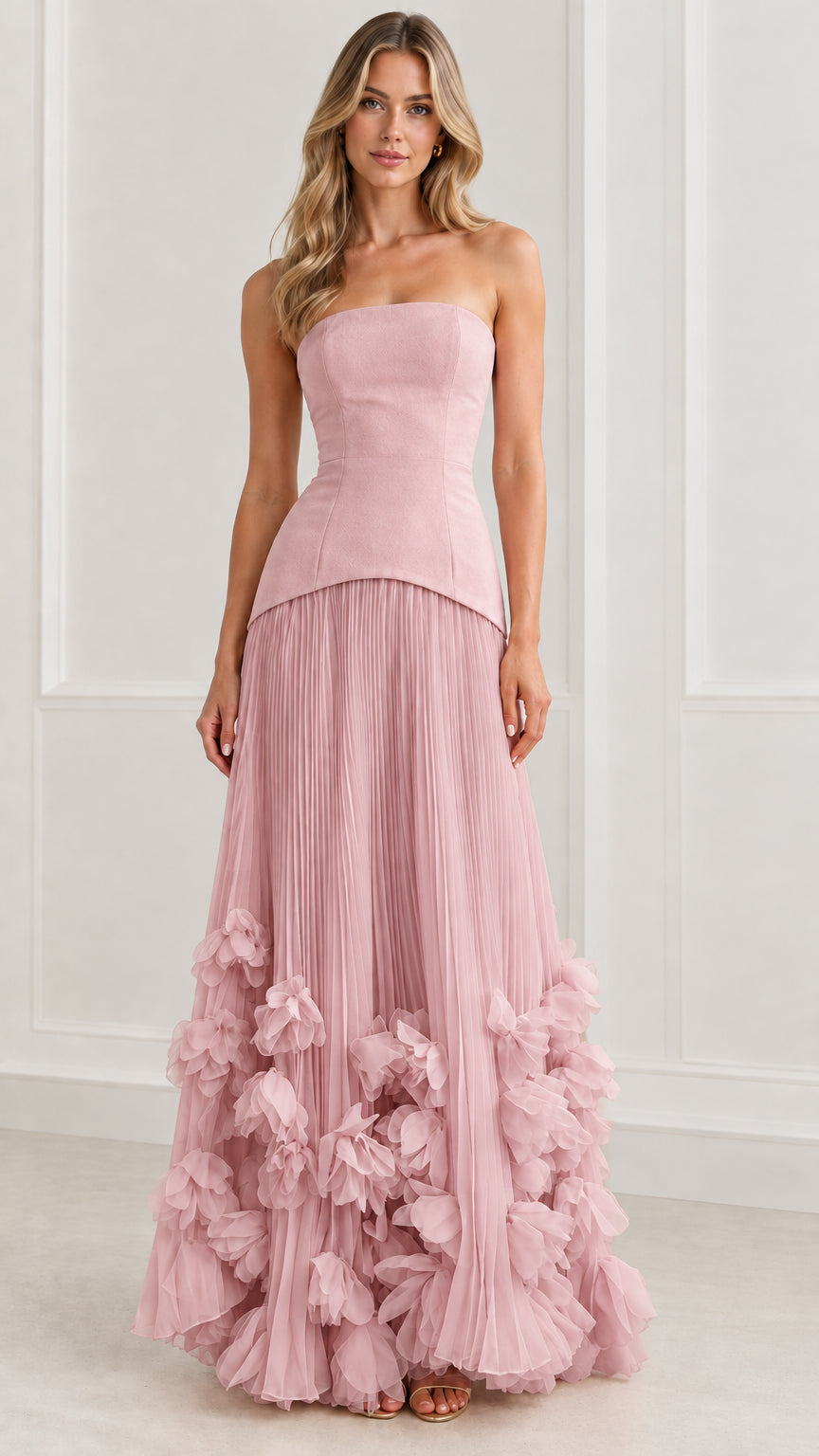 Front view of model wearing dusty pink strapless pleated evening gown with floral hem