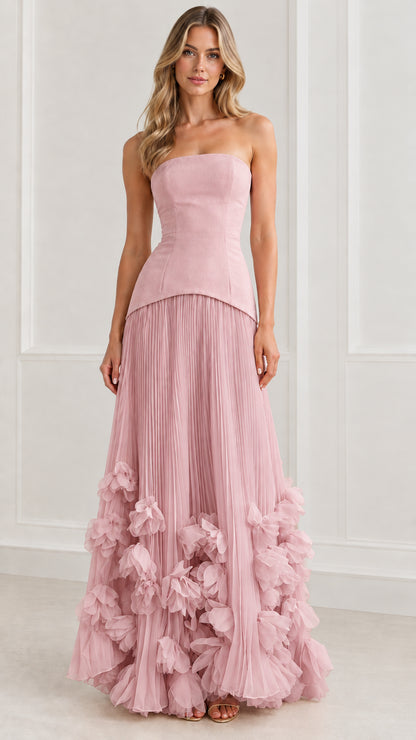 Front view of model wearing dusty pink strapless pleated evening gown with floral hem