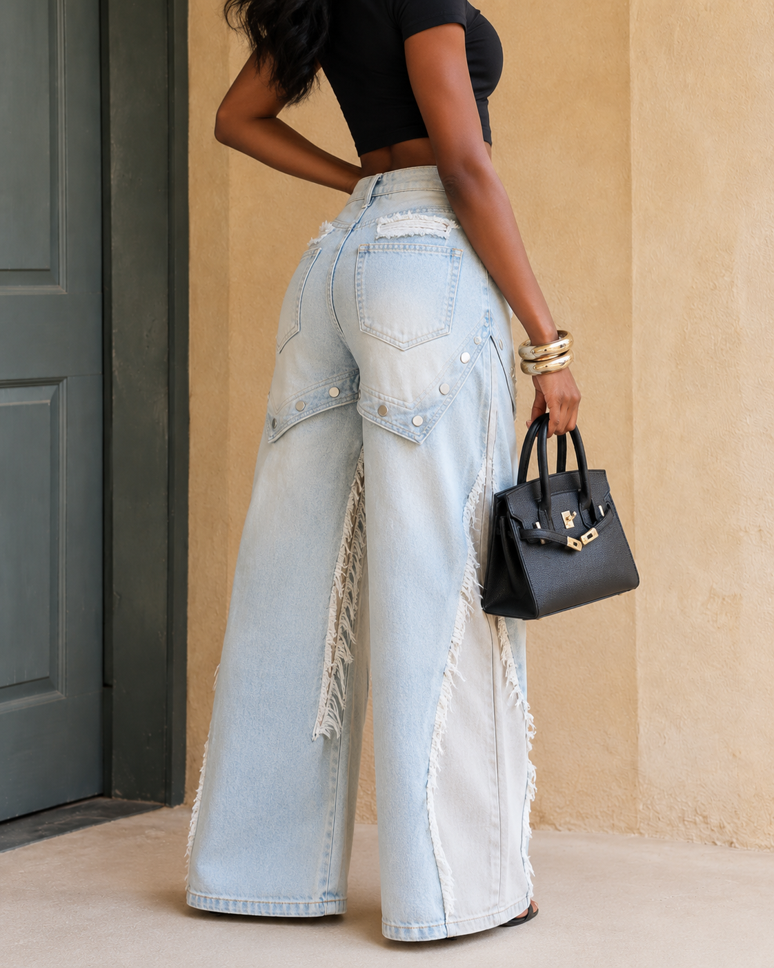 Back side view of light wash wide leg jeans showing relaxed leg shape and frayed side details