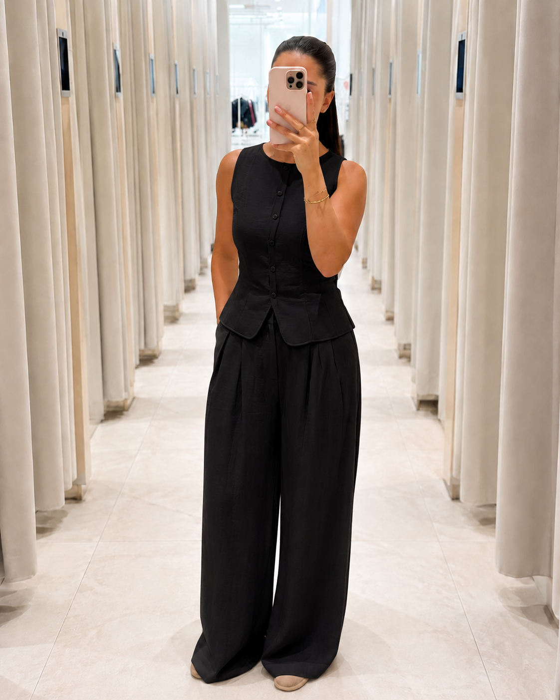 Front view of black sleeveless peplum top and wide leg pants matching set