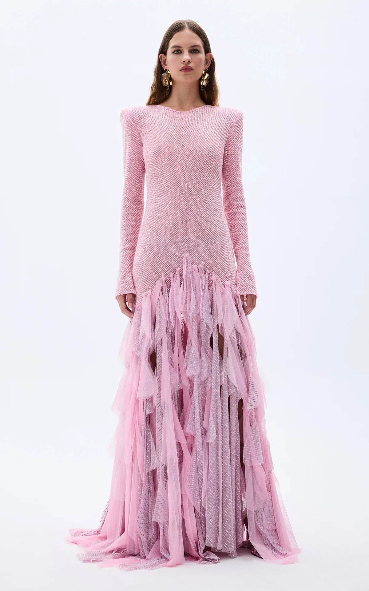 Front view of blush pink fitted evening gown with long sleeves and layered ruffle skirt